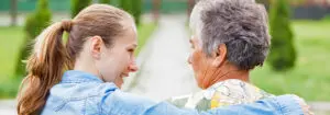 Younger woman with her arm around senior woman