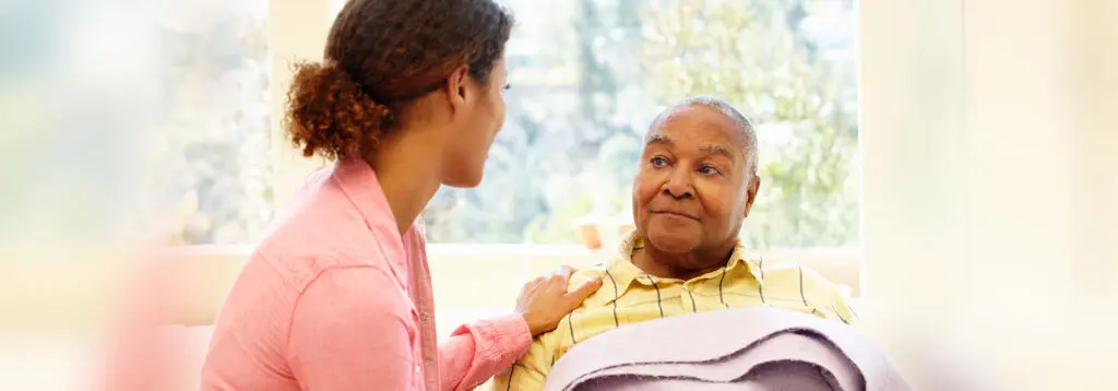 Younger woman speaking to elderly man