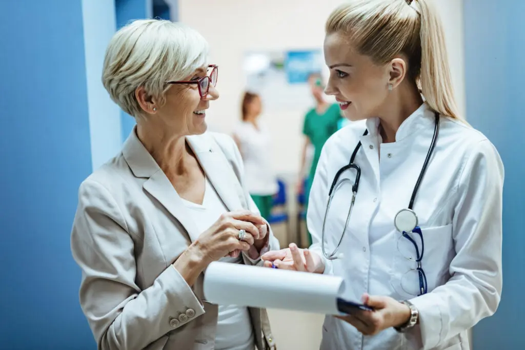 Older woman speaking to female doctor