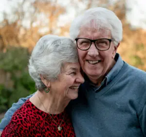 Elderly couple hugging and smiling
