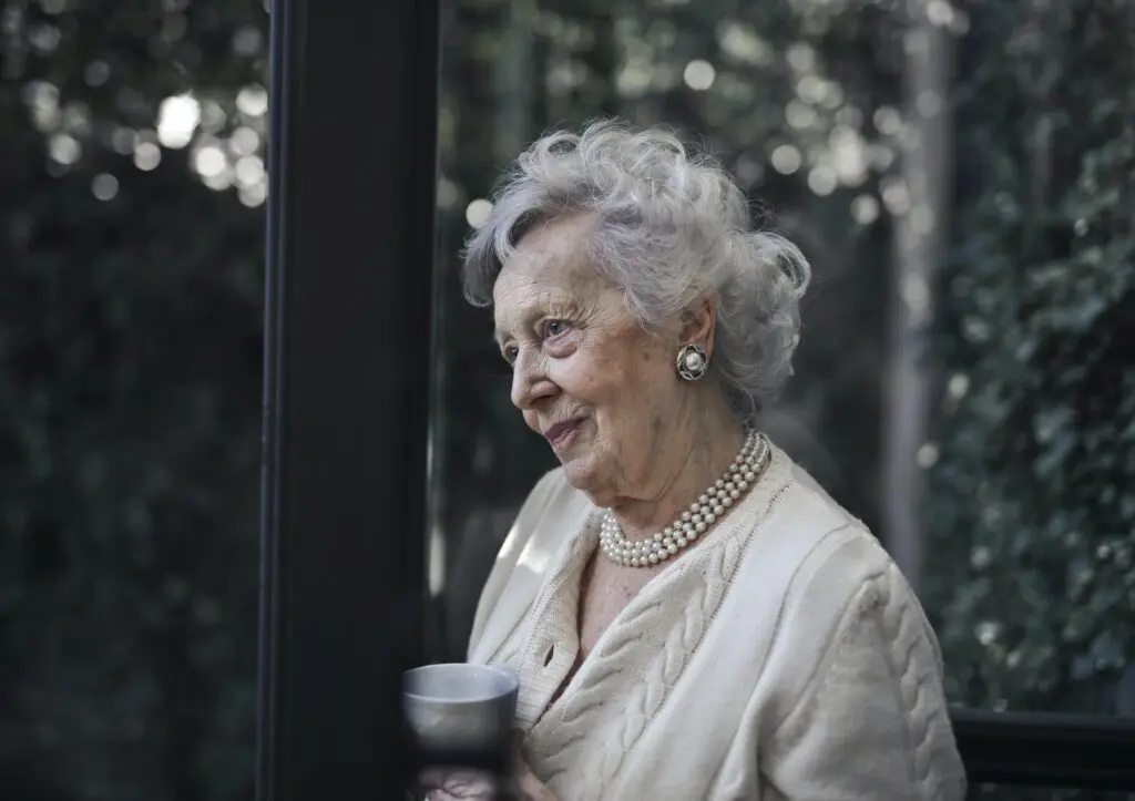 Senior woman holding cup and standing outside