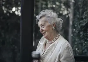 Senior woman holding cup and standing outside