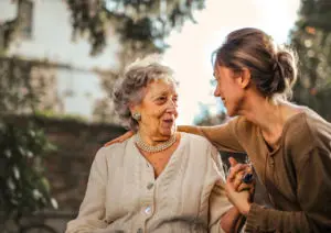 an older woman sitting and looking at a younger woman