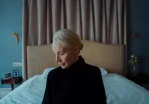 older woman sitting on a bed