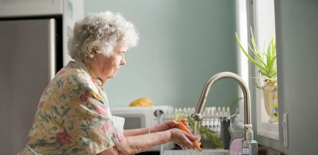 woman washing vegetables in the sink