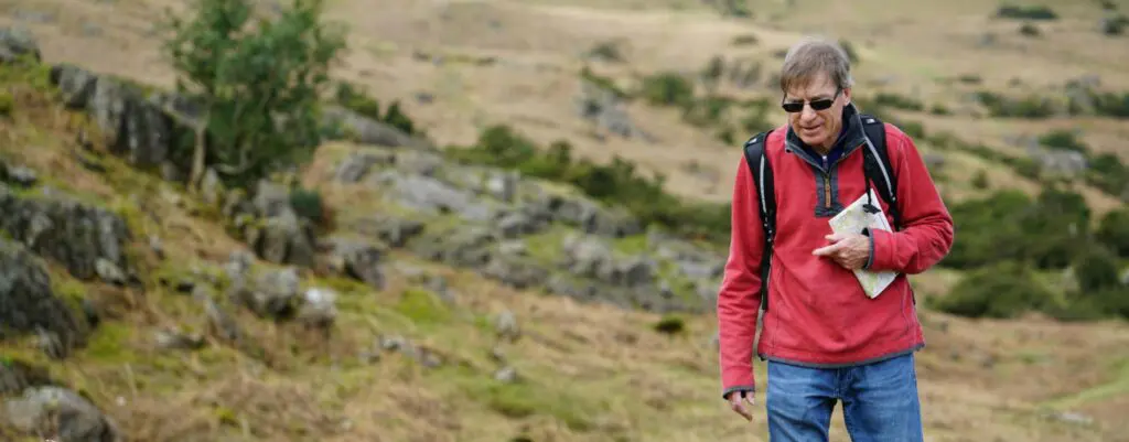 Man Wearing Red Jacket Walking on Pathway