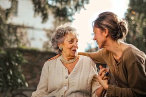 elderly woman speaking to middle-aged woman in garden