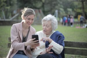 young woman showing elderly woman her phone screen