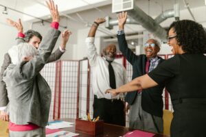 group of elderly professionals celebrating in office