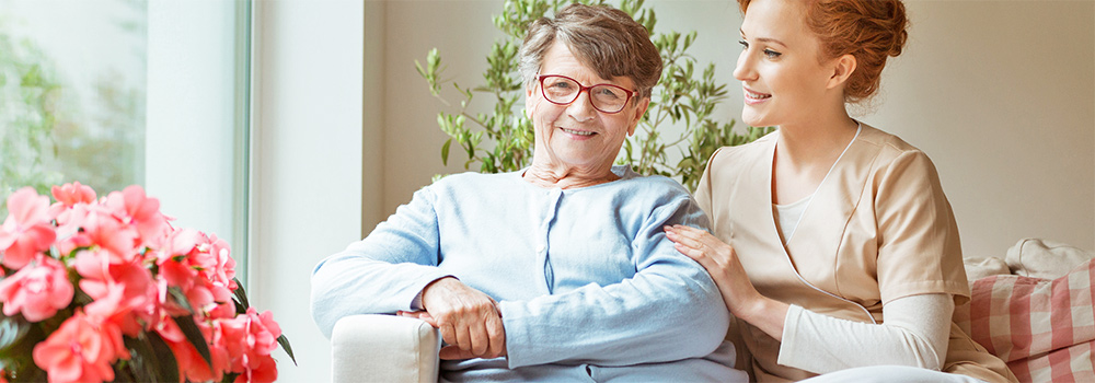 Elderly woman sitting on couch with nurse
