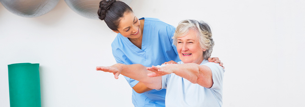 Nurse assisting elderly woman working out