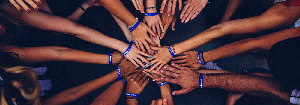 Group of people putting hands together in a circle