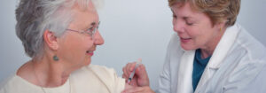 Female doctor giving elderly woman a shot