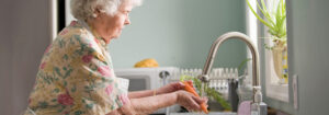 elderly woman washing carrots