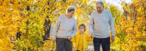 Senior couple walking with young grandson in nature