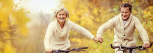 Senior couple riding bikes and holding hands