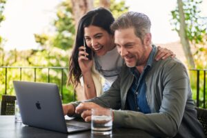 Couple looking at laptop outside