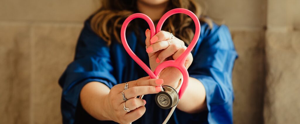 Woman folding stethoscope in shape of heart