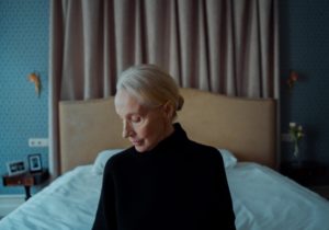 older woman sitting on a bed
