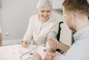 A Man Checking the Elderly Woman's Blood Pressure