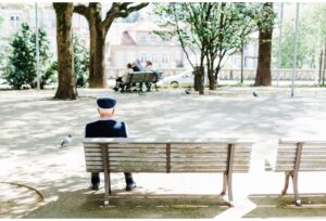 man sitting alone on a bench in park