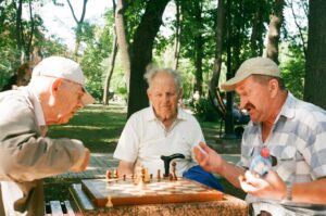 friends playing a game of chess outside