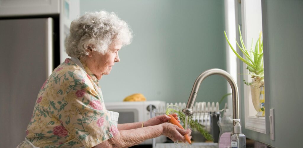 woman washing vegetables in the sink